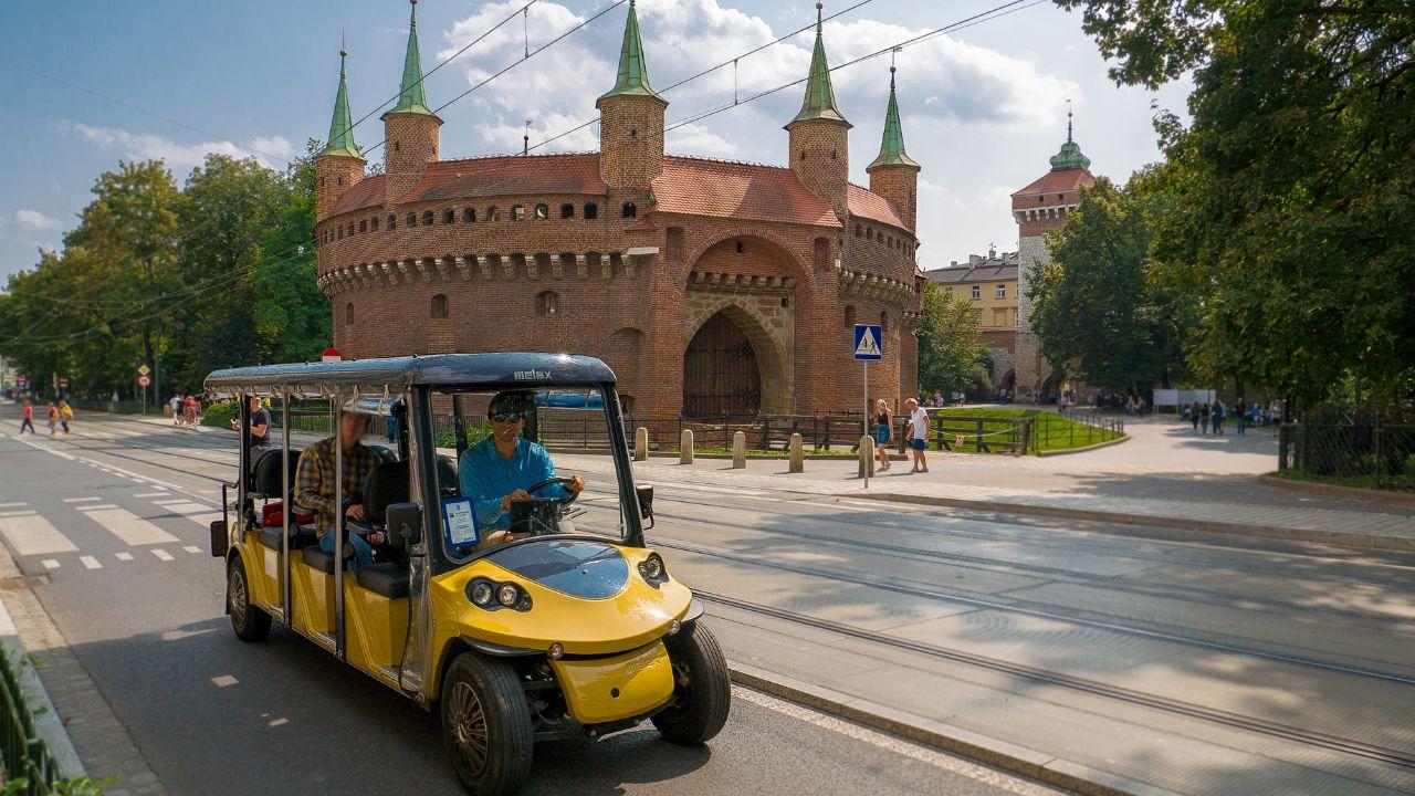 Turisti che godono di un tour di Cracovia in un melex ecologico.
